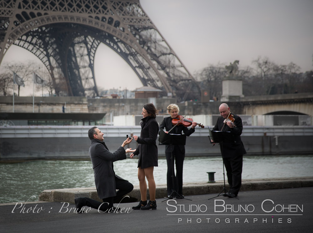surprise proposal in paris front Eiffel Tower musicians violinists emotions couple in love 