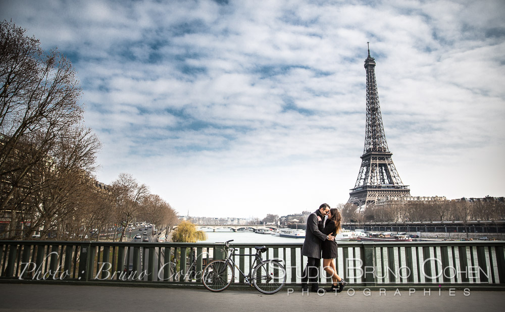 proposal in paris kissing couple from de Bir-Hakeim bridge at daylight front of Eiffel Tower blue sky 