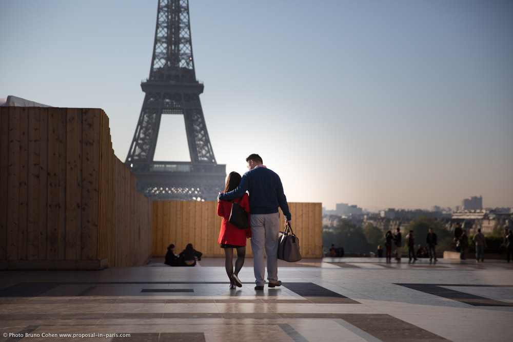couple walk on Trocadero front of Eiffel Tower in love at sunrise