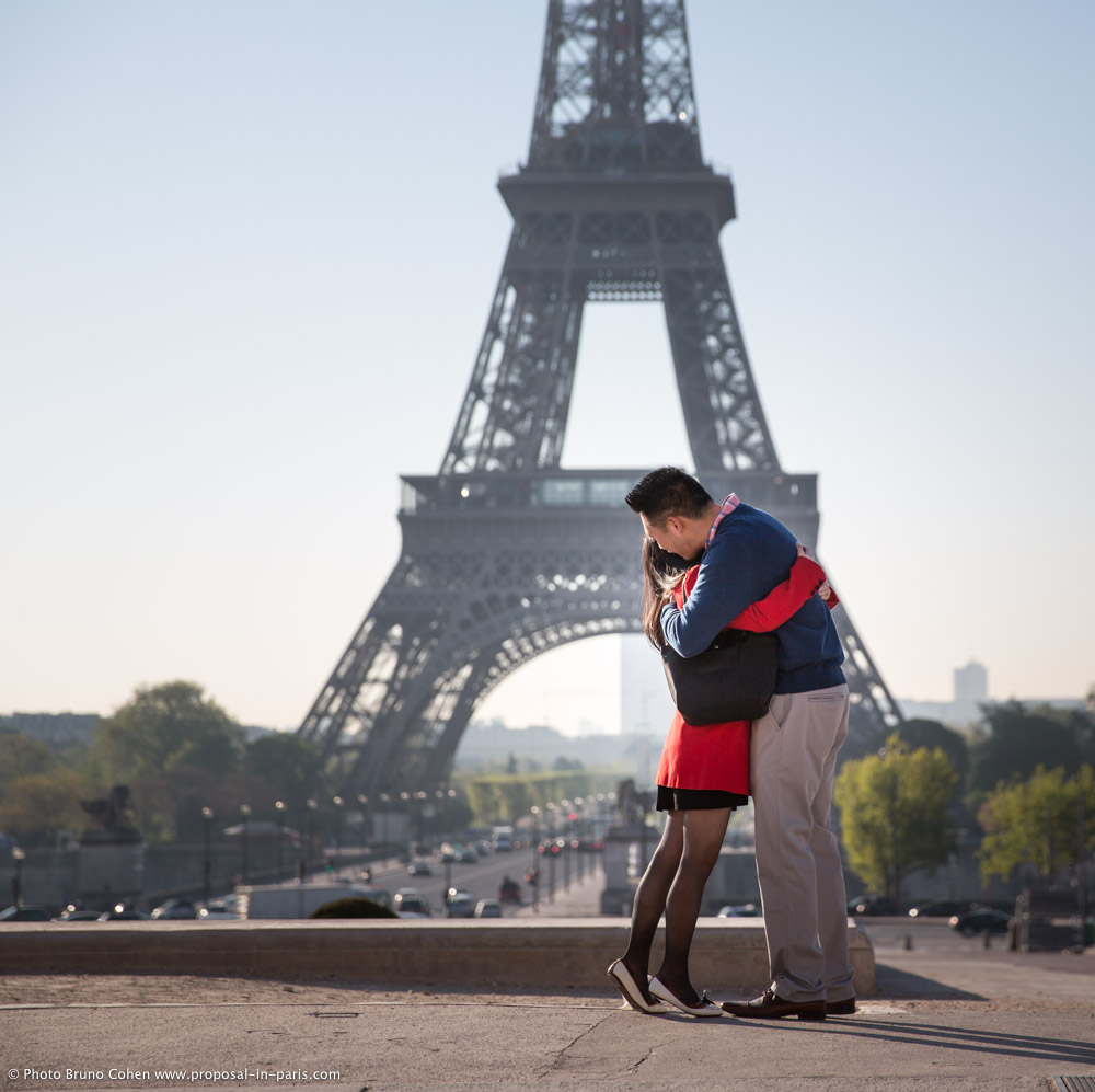 hugging couple in love from Trocadero front of Eiffel Tower at sunrise proposal in paris