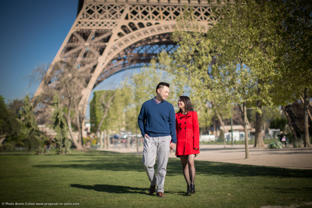couple walk in champs de mars in paris front of Eiffel Tower proposal 