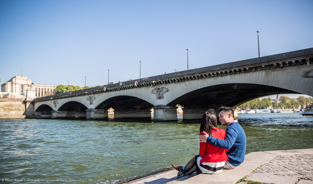 hugging couple in paris from seine banks front of Eiffel Tower love engagement session