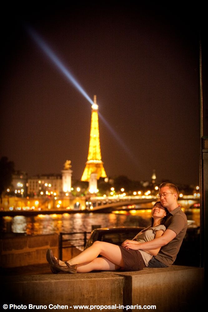 couple hugging in paris front of Eiffel Tower at night proposal