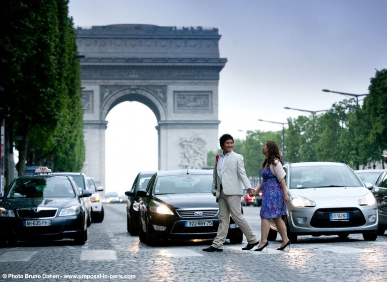 proposal in paris couple asian crossing road at sunrise arc de triomphe hand and hand
