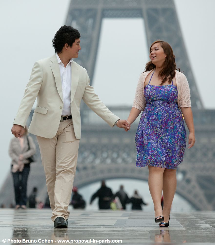 portrait asian couple hand in hand walking from Trocadero front of Eiffel Tower 