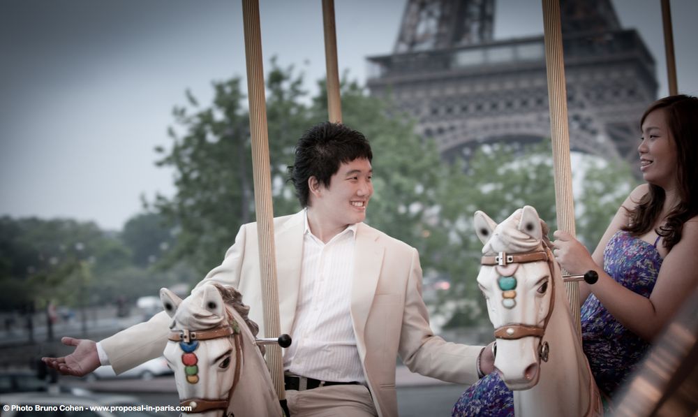 portrait men in suit riding horse at carousel front of Eiffel Tower proposal in paris