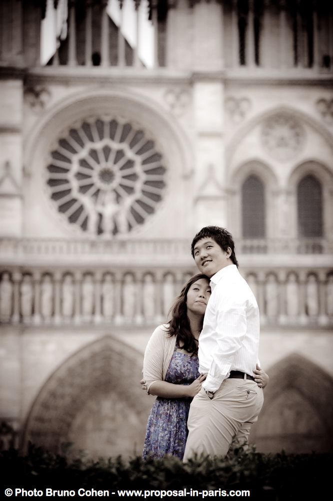 fashion portrait asian couple from notre dame cathedral smile engagement proposal in paris 