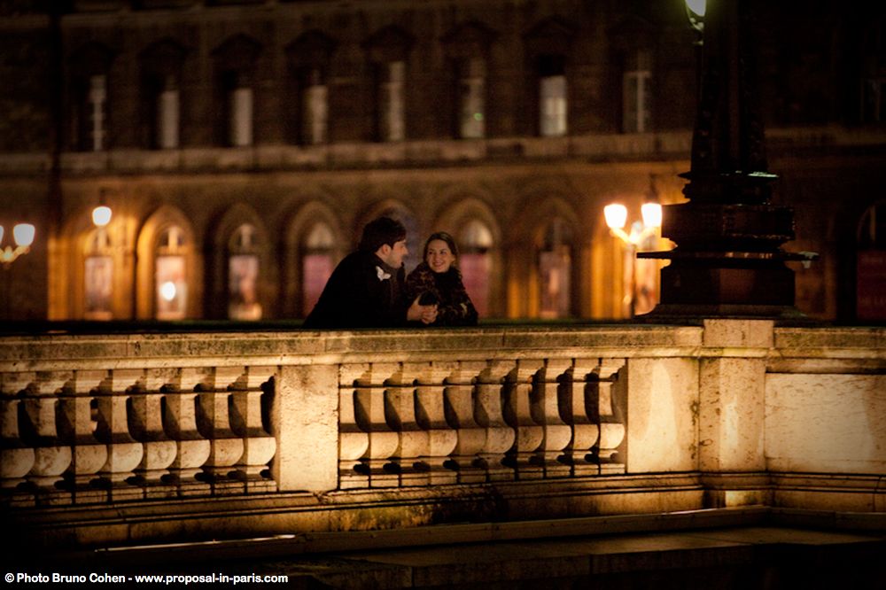 portrait couple in love on bridge at night in paris proposal