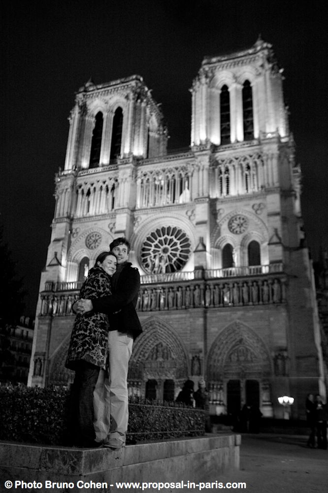 portraithugging couple in love front of notre dame cathedral at night proposal