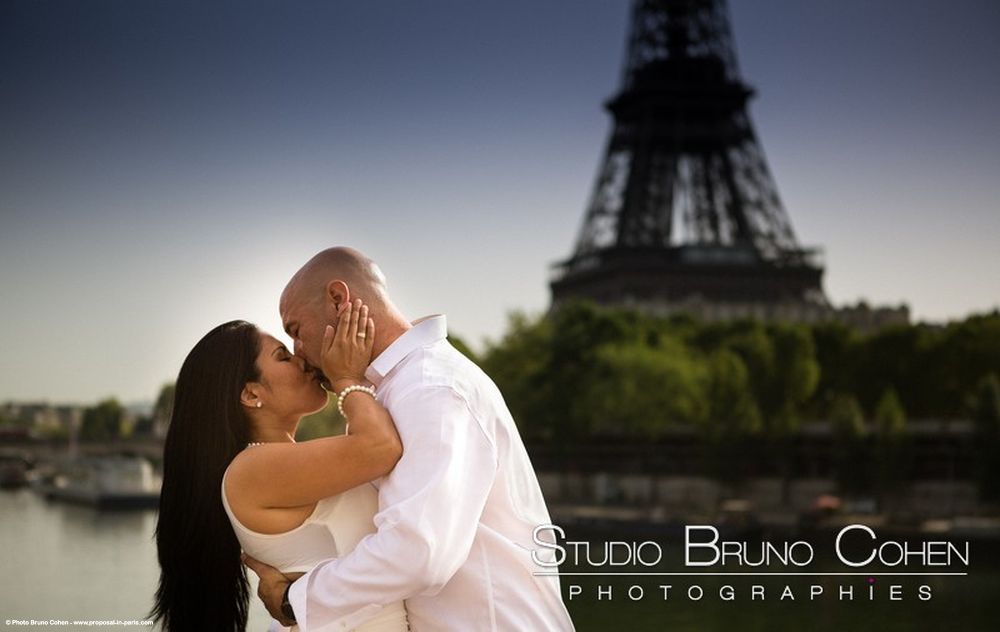 engagement session kissing couple from bir hakeim bridge front of Eiffel Tower blue sky at sunset 