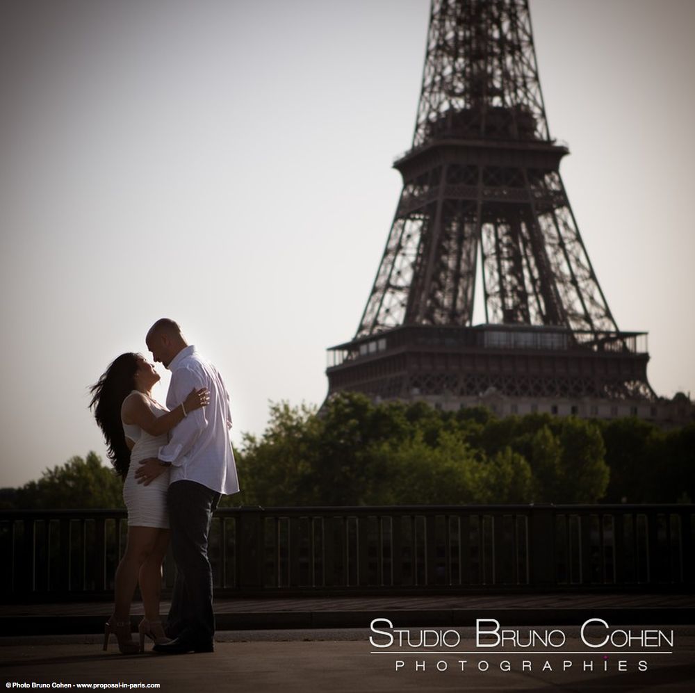 engagement session couple in love hugs from bir hakeim bridge front of Eiffel Tower at sunrise