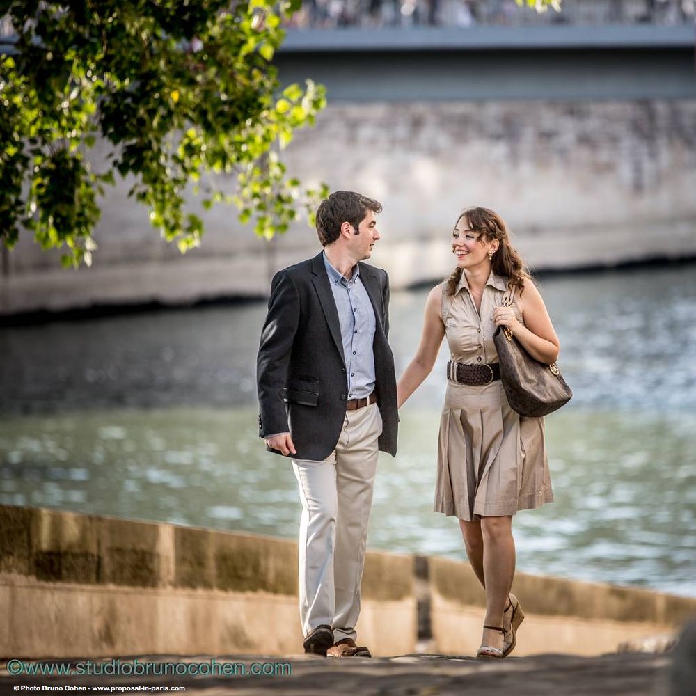 portrait walking couple in love face to face hand in hand quai de seine in paris 