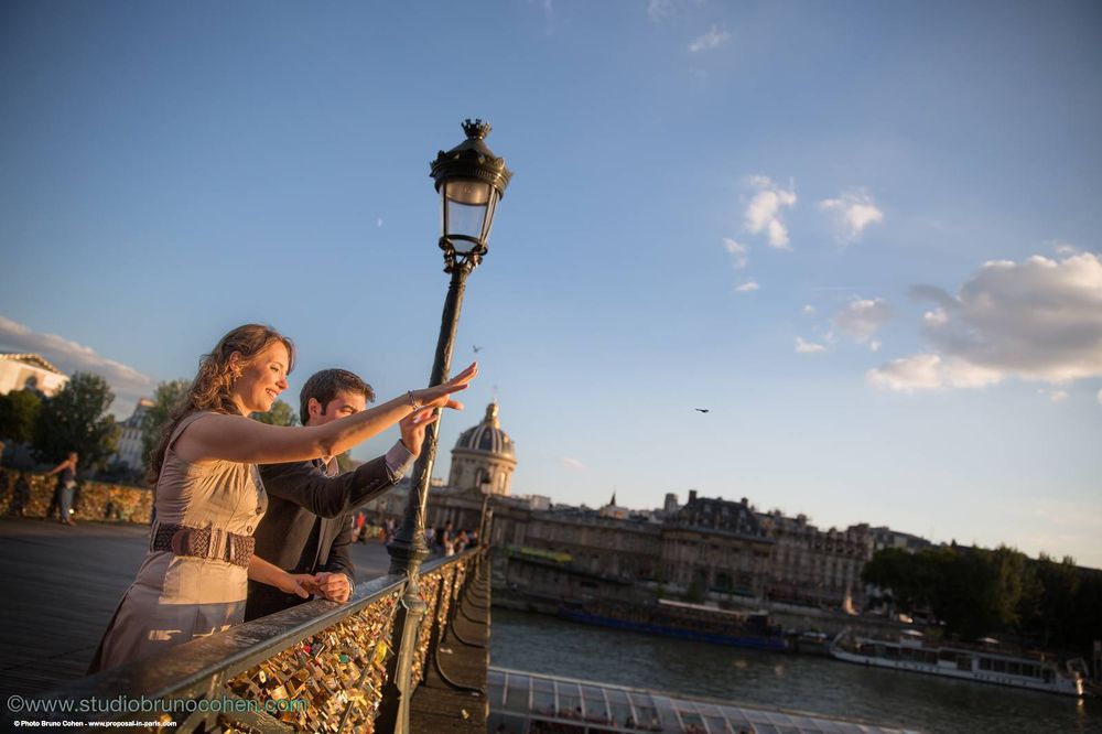 proposal in paris Turkish couple look far away  at sunset near Eiffel Tower