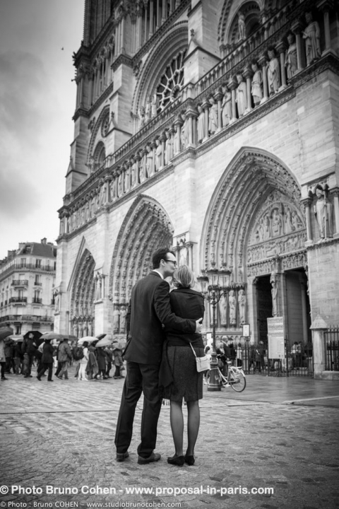 portrait couple in love front of notre dame cathedral in paris proposal black and white