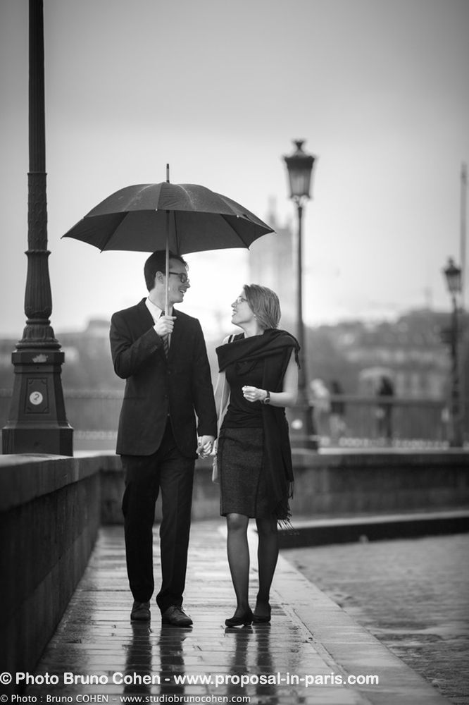 portrait couple walking in paris umbrella cloudy black and white
