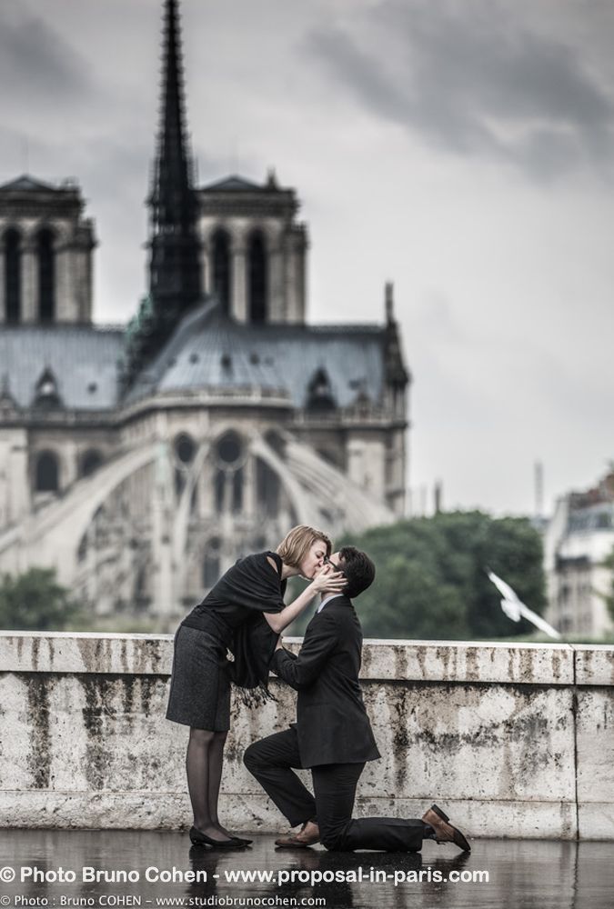 surprise proposal in paris kissing couple notre dame cathedral front of love emotion