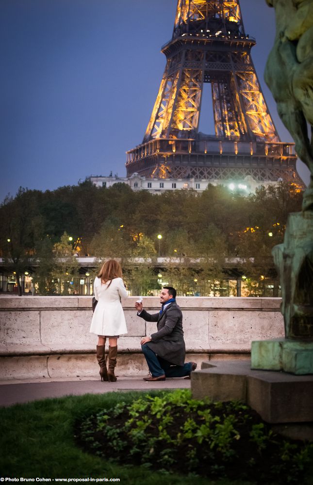 surprise proposal in paris front of Eiffel Tower couple in love emotions smile at night