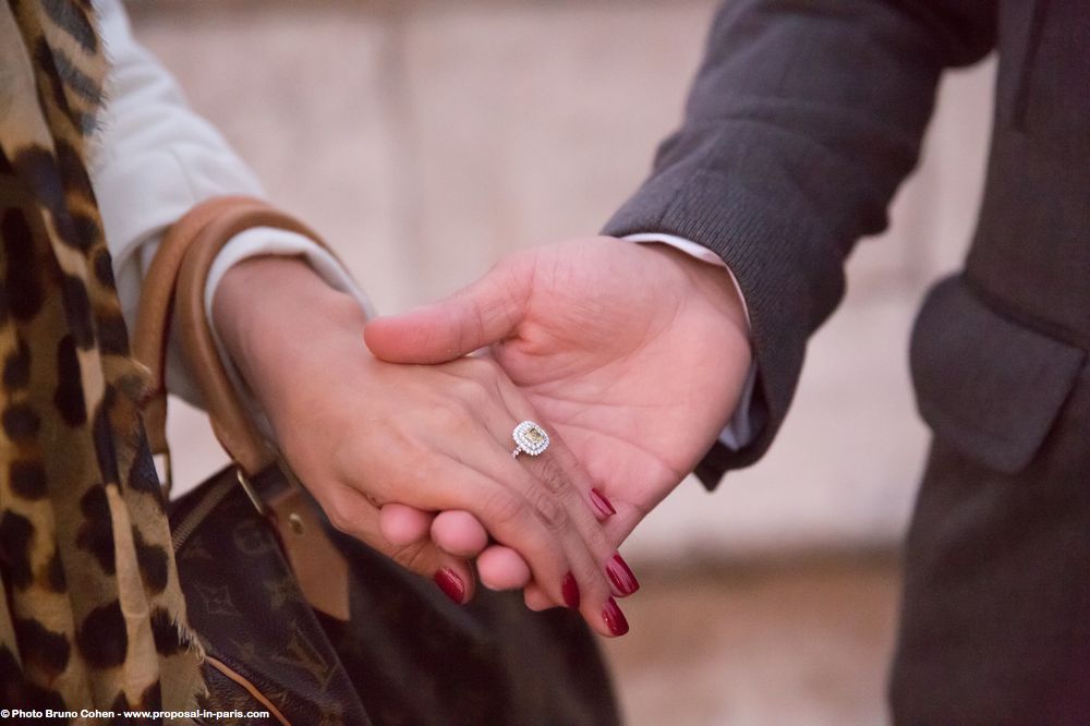 proposal in paris focus engagement ring hand in hand