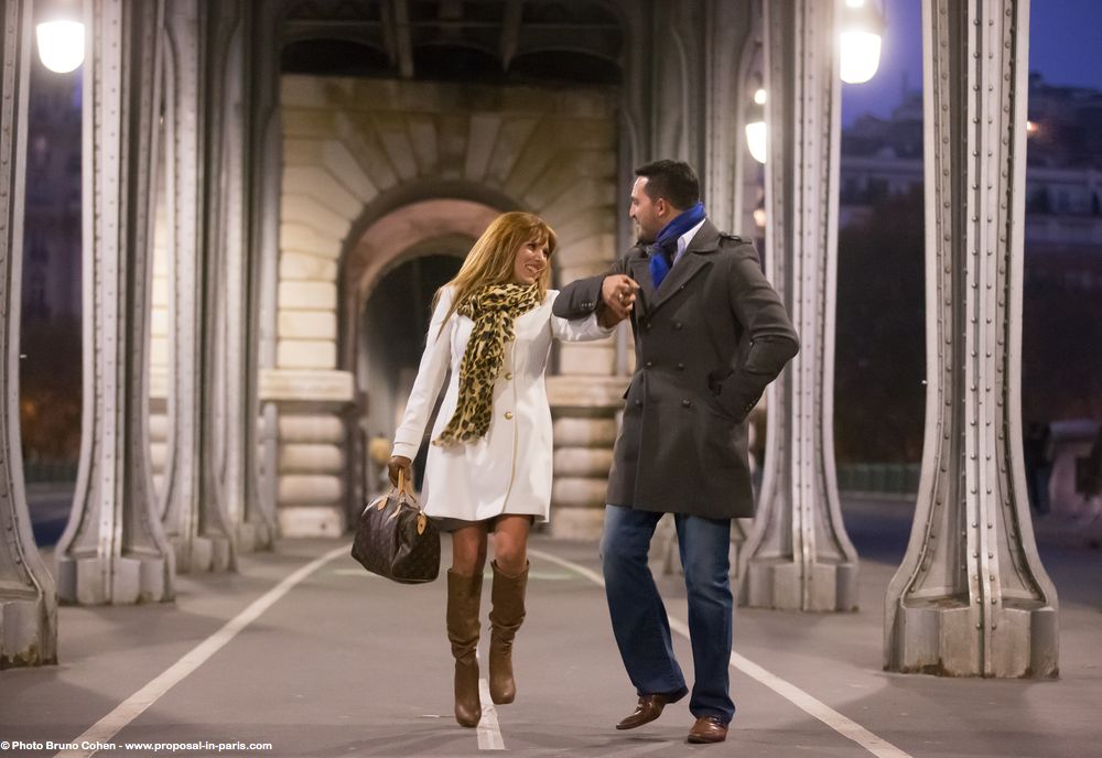 portrait couple hand in hand jump from bir hakeim bridge in paris near Eiffel Tower at night engagement session