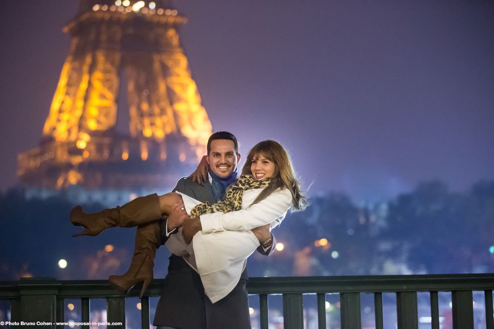 portrait couple in love hugging from bir hakeim bridge front of Eiffel Tower proposal in paris at night