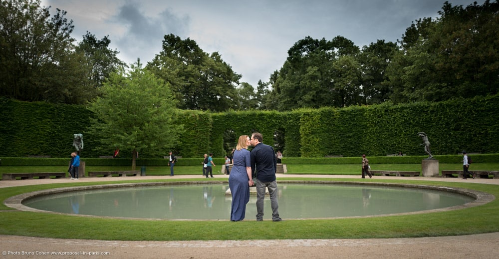 kissing couple hand in hand standing front of fountain Rodin museum kiss