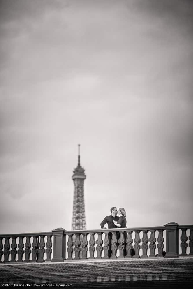 proposal in paris kissing couple front of Eiffel Tower bridges black and white