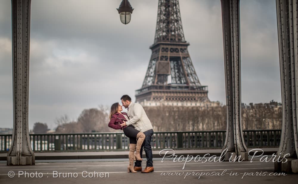winter proposal in paris couple dancing in love from bir hakeim bridge front of Eiffel Tower