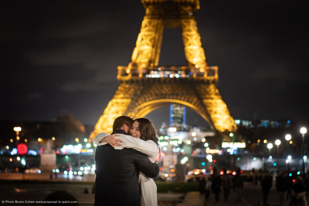 hugging couple front of Eiffel Tower at night