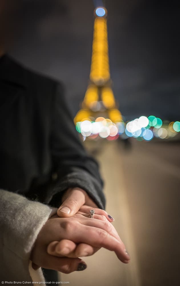 proposal focus ring hand in hand front the Eiffel Tower at night