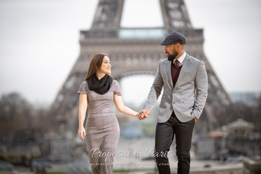 young couple walking in front of the Eiffel Tower Paris