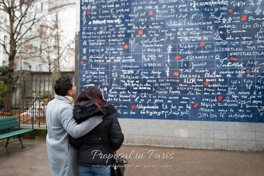 couple looking at the Love Wall in Montmartre Paris