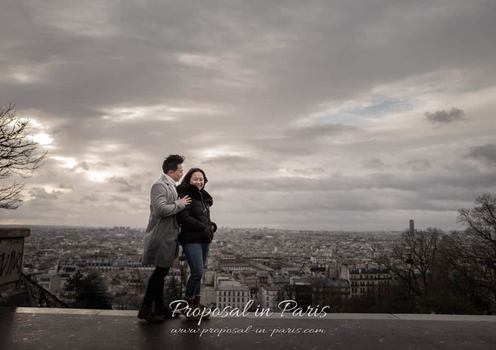 couple overlooking paris from montmartre at the sunset