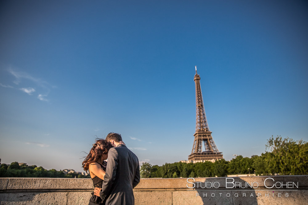 portrait couple in love hugging on bir hakeim bridge front of eiffel tower from paris proposal at sunset summer blue sky 