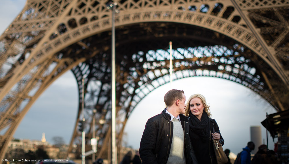 couple walk in paris front of Eiffel Tower proposal love
