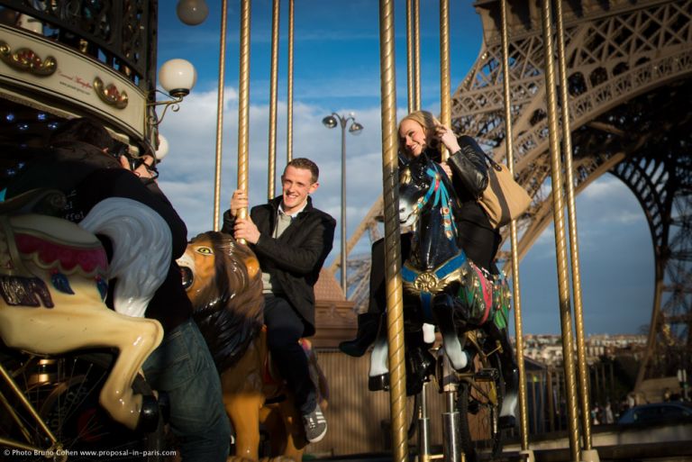 couple ride on horses from Eiffel Tower carousel in paris happy 