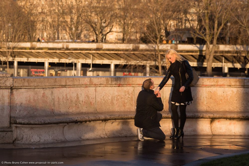 surprise proposal in paris at sunset from Bir Hakeim bridge front of Eiffel Tower couple in love emotions cry