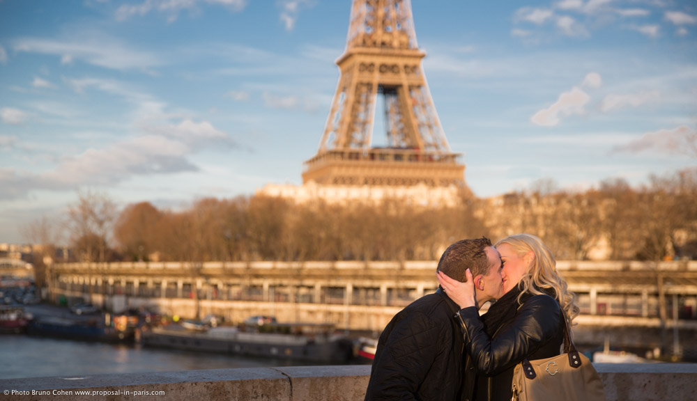 surprise proposal in paris kissing couple on Bir Hakeim bridge front of Eiffel Tower at sunset 