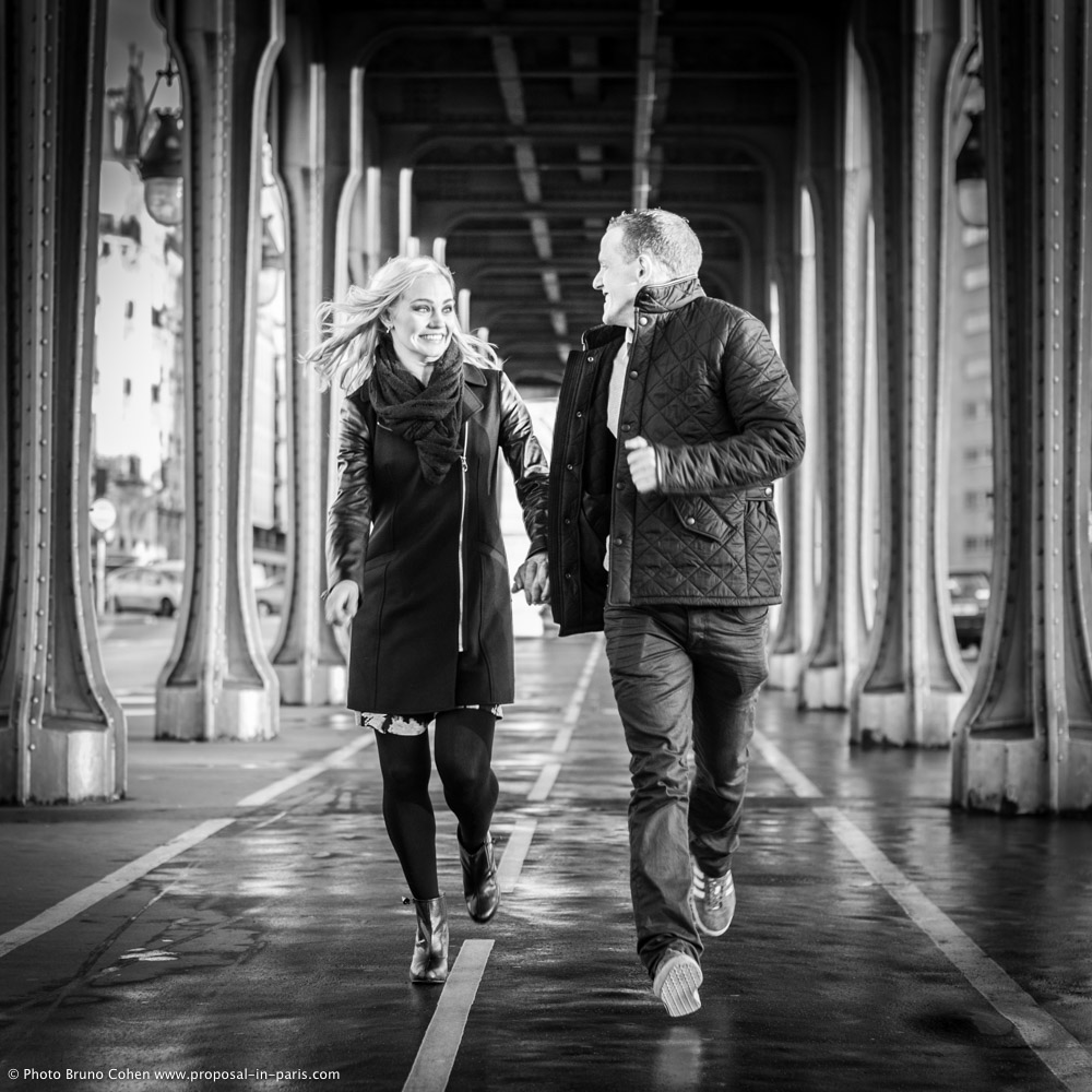 running couple in love under Bir Hakeim bridge in paris black and white 
