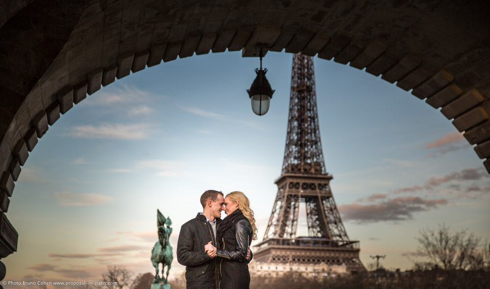 portrait couple in love forehead against forehead under Bir Hakeim bridge front of Eiffel Tower in paris at sunset 