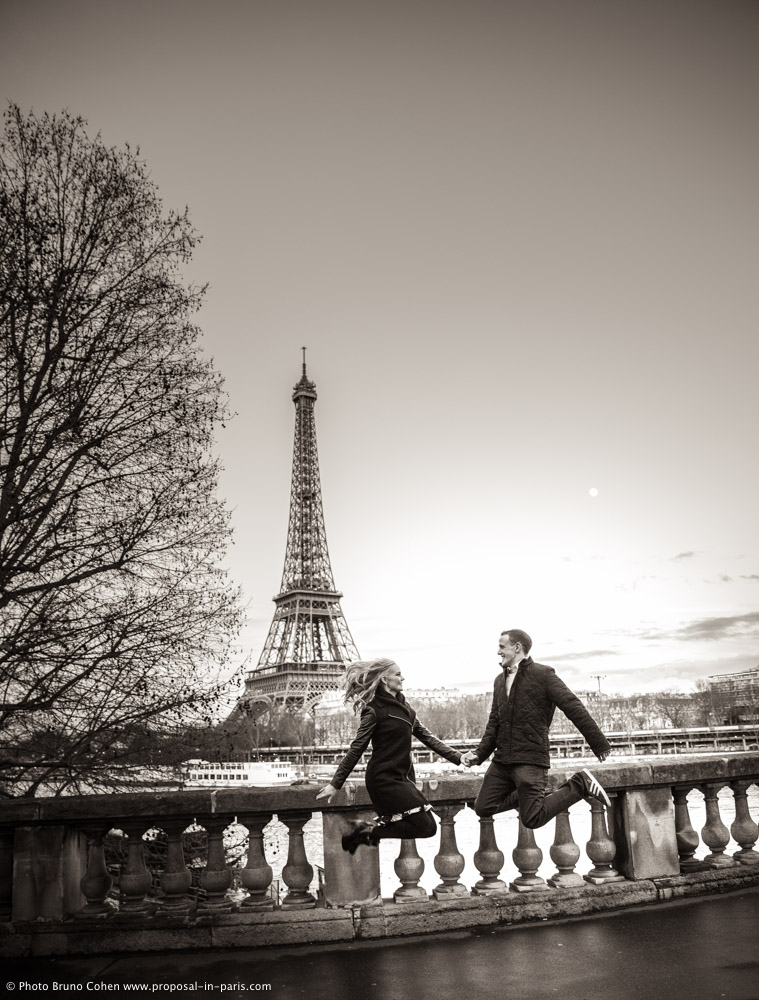 jumping couple in love front of Eiffel Tower in paris sunset black and white
