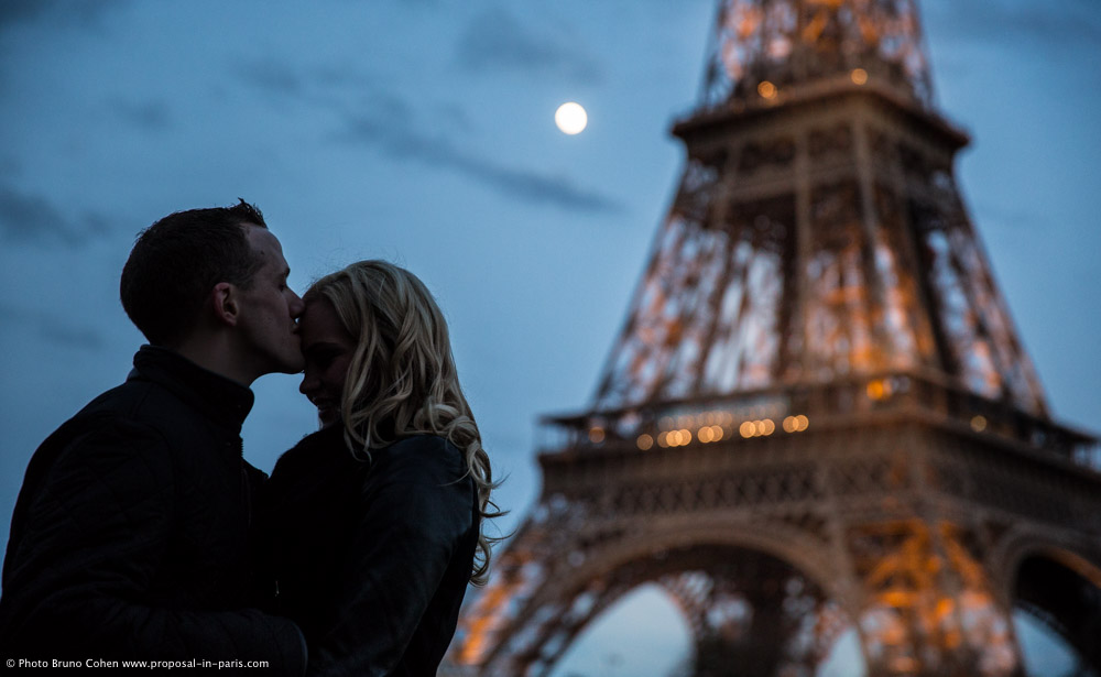 kissing couple forehead at night front of Eiffel Tower paris