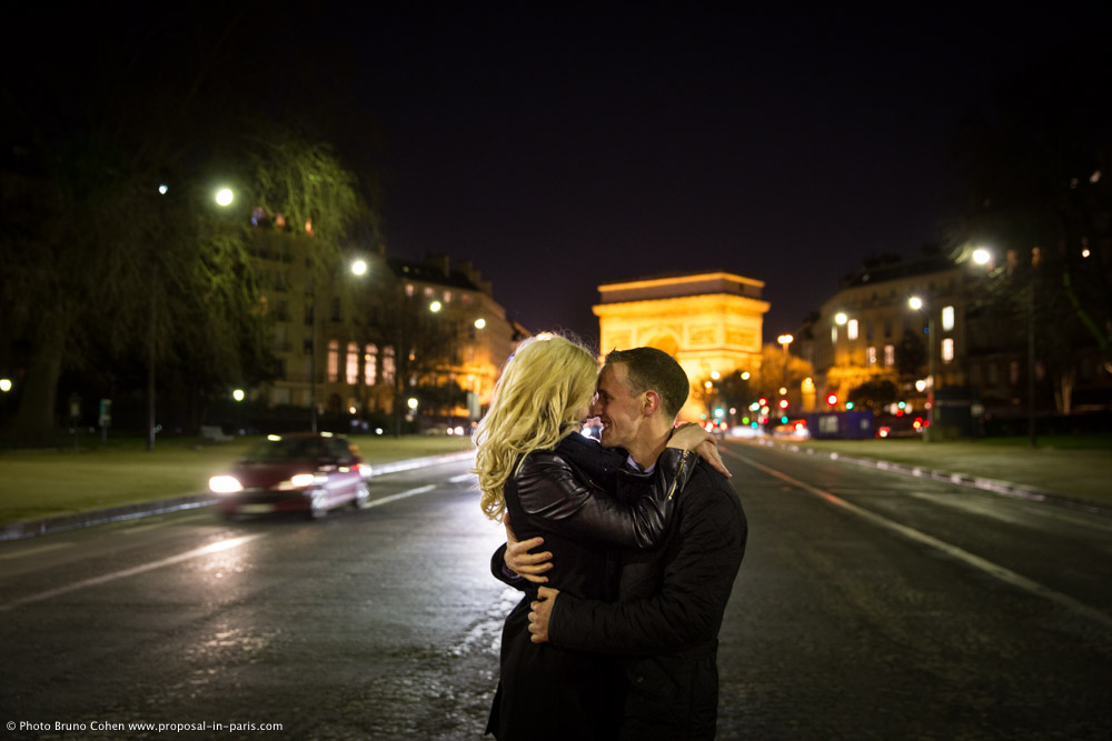 hugging couple in love from arc de triomphe paris at night