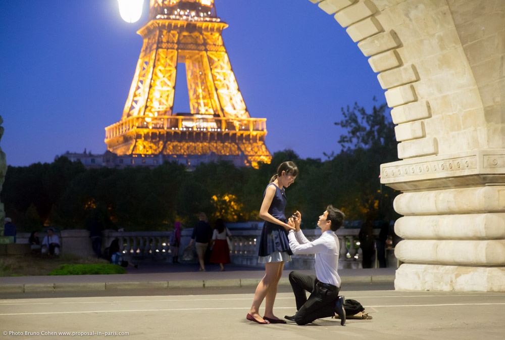 surprise proposal in paris by night front of Eiffel Tower from Bir Hakeim bridge