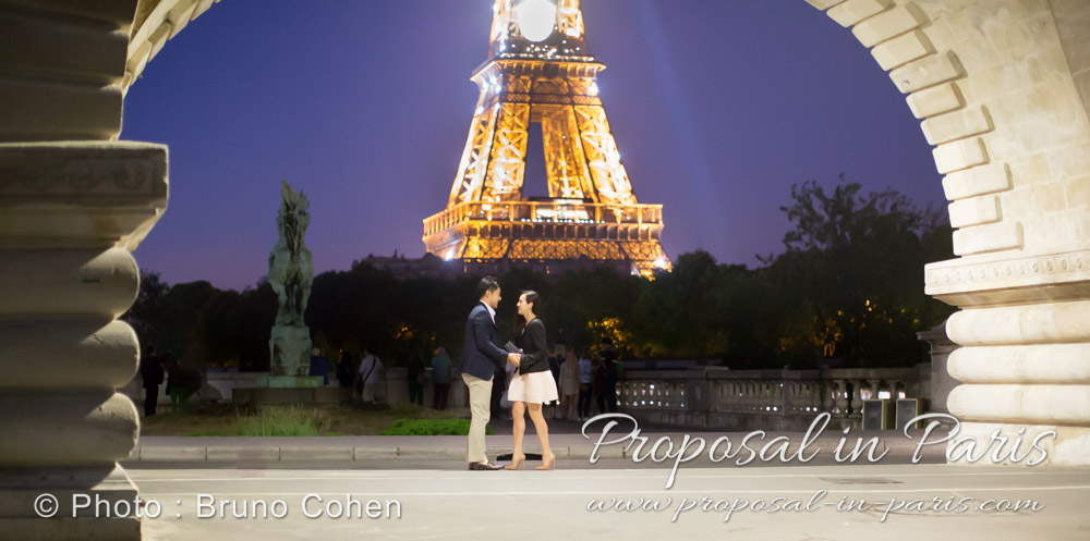 couple face to face from Bir Hakeim bridge front of Eiffel Tower by night in paris