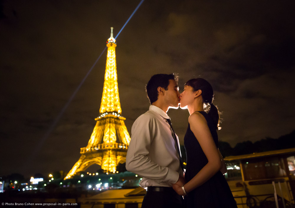 portrait kissing asian couple by night in paris front of Eiffel Tower 