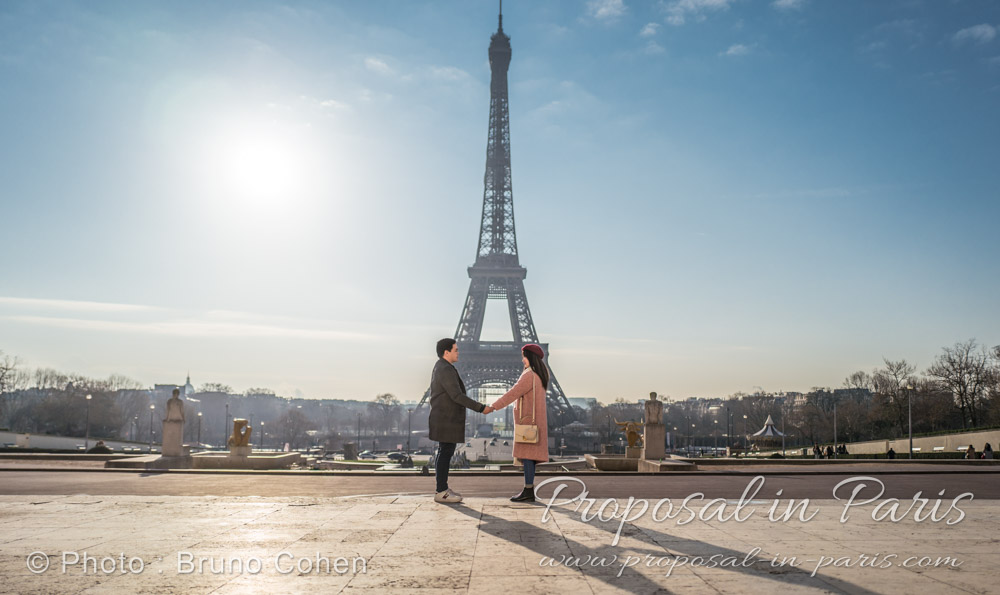 Eiffel Tower at sunrise with a couple holding hands