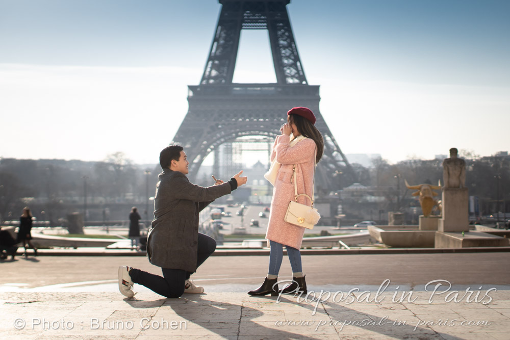 man down on one knee during a proposal in front of Eiffel Tower