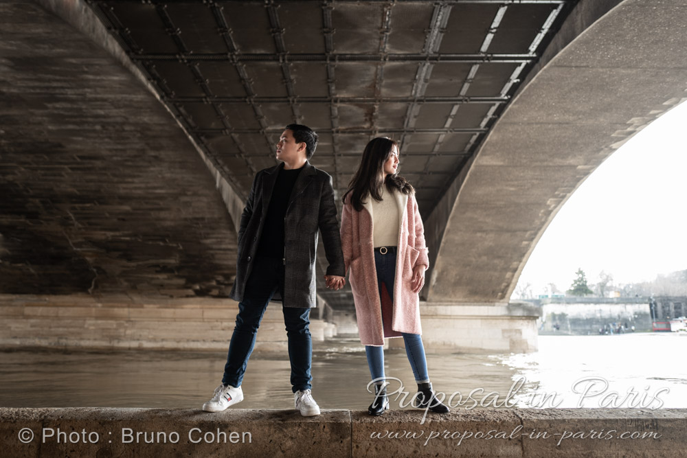 young asian couple standing up under Iena bridge in Paris