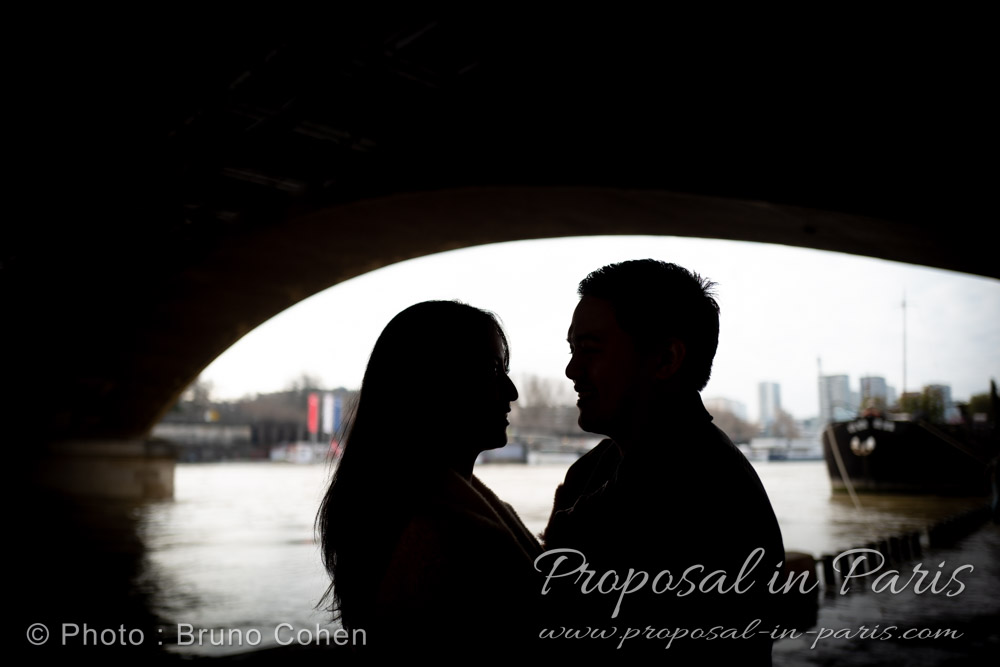 silhouettes en contre jour d'un couple qui se regarde, arche d'un pont au dessus d'eux