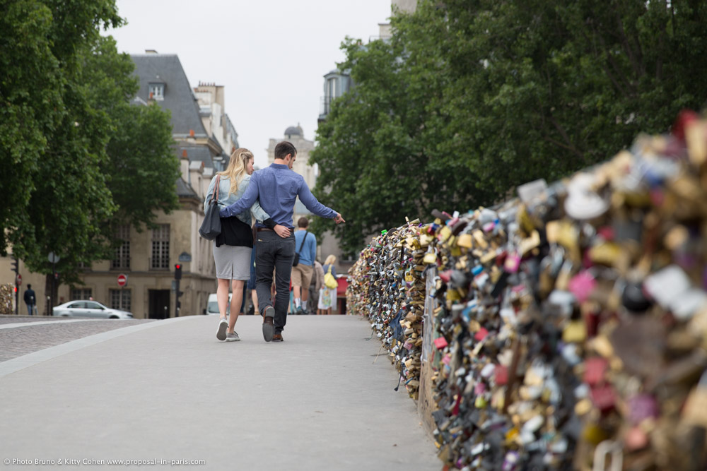 portrait couple walking from lock bridge in paris with love
